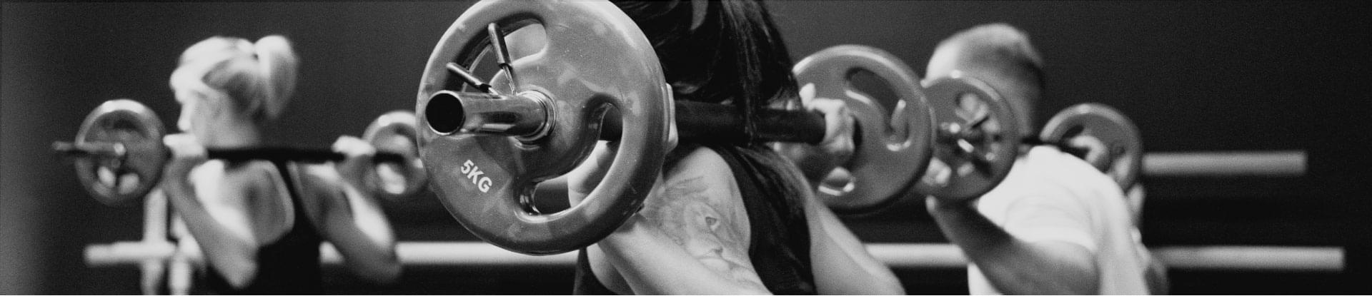 people training with weights on their shoulders